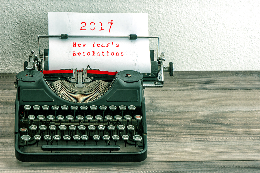 Typewriter with white paper page on wooden table. sample text 2017 New Year's Resolutions. vintage style toned picture